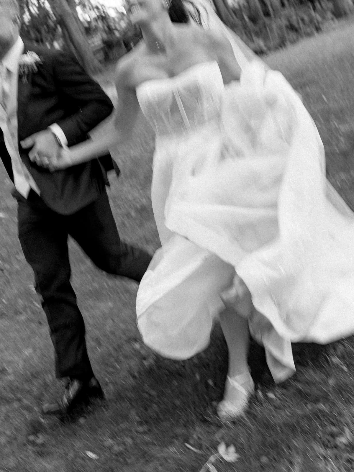 A flash photograph of a couple mid-run, her dress gathered in one hand.